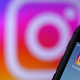 The Instagram icon is shown on a smartphone. A larger version of the icon in the background can also be seen.